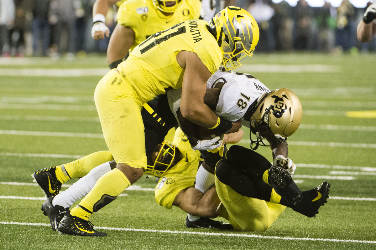 Isaac Slade-Matautia tackles wide receiver Tony Brown in a game against the Colorado Buffaloes at Autzen Stadium.